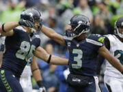 Seattle Seahawks quarterback Russell Wilson (3) congratulates Zach Miller on Miller's second touchdown reception against the Jacksonville Jaguars in the first half Sunday.