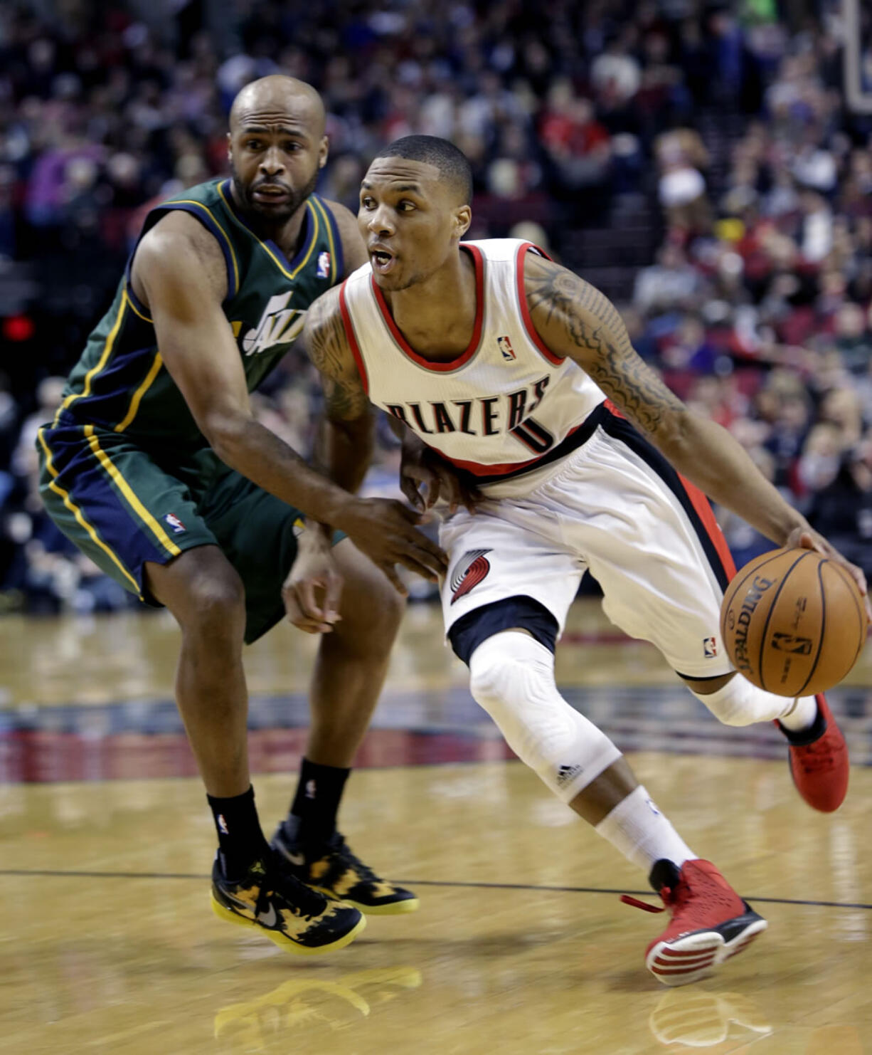 Portland Trail Blazers guard Damian Lillard, right, drives past Utah Jazz guard Jamaal Tinsley during the first quarter Saturday.