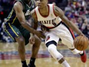 Portland Trail Blazers guard Damian Lillard, right, drives past Utah Jazz guard Jamaal Tinsley during the first quarter Saturday.