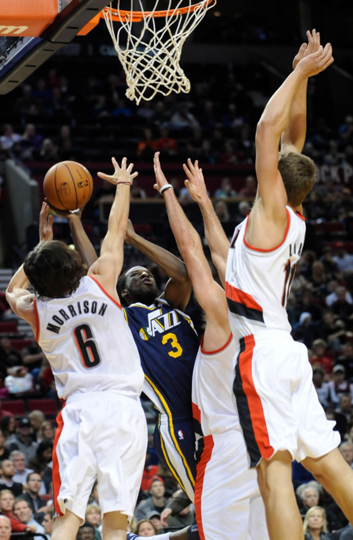 Meyers Leonard, right, puts up a defensive blockade with Adam Morrison, left, and Joel Freeland against Utah Jazz's DeMarre Carroll.