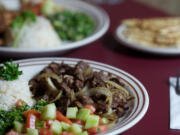 The Garlic Lemon Chicken and Lamb Shawarma, foreground, are two standout menu items available at the downtown Vancouver Jerusalem Cafe.