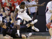 Kansas State's Will Spradling, left, tumbles after bumping into Gonzaga's Guy Landry Edi as the two raced for a loose ball in Gonzaga's win.