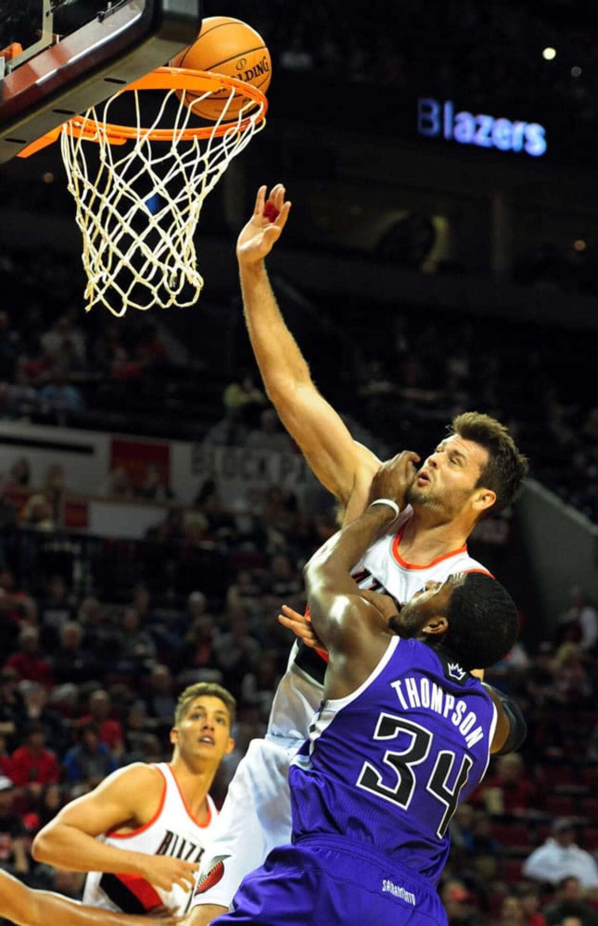 Portland Trail Blazers forward Joel Freeland (19) is fouled to Sacramento Kings forward Jason Thompson (34) as he drives to the basket during the first half of an NBA basketball game Sunday, Oct. 20, 2013, in Milwaukee.