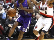 Sacramento Kings guard Aaron Brooks, left, drives the baseline against Portland Trail Blazers guard Damian Lillard during the first quarter Saturday.