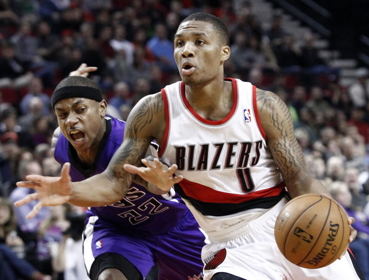 Portland Trail Blazers guard Damian Lillard, right, drives past Sacramento Kings guard Isaiah Thomas during the second half of an NBA basketball game in Portland, Ore., Wednesday, Dec. 26, 2012. Lillard scored 17 points and dished out 11 assists as the Trail Blazers won 109-91.