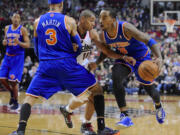 New York Knicks' J.R. Smith (8), with a screen by teammate Kenyon Martin (3), drives against Portland Trail Blazers' Nicolas Batum (88) during the first half of an NBA  basketball game in Portland, Ore., Thursday, March 14, 2013.