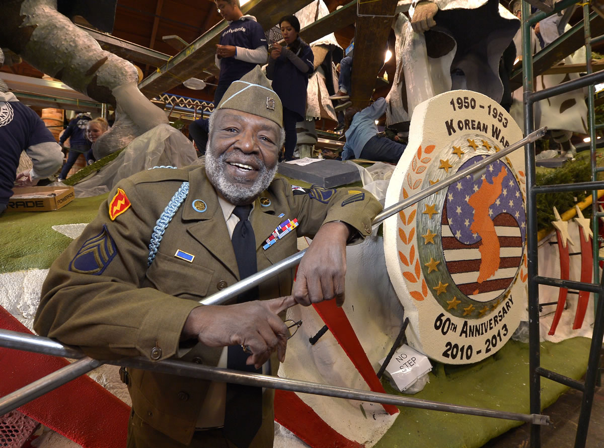 Korean War veteran James McEachin, 82,  stands in front of the float in Pasadena, Calif.