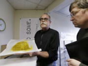 Jim Andersen, left, shows butane hash oil to Mike Steenhout, comptroller of Washington's Liquor Control Board, at a marijuana-growing facility April 4 in Seattle.