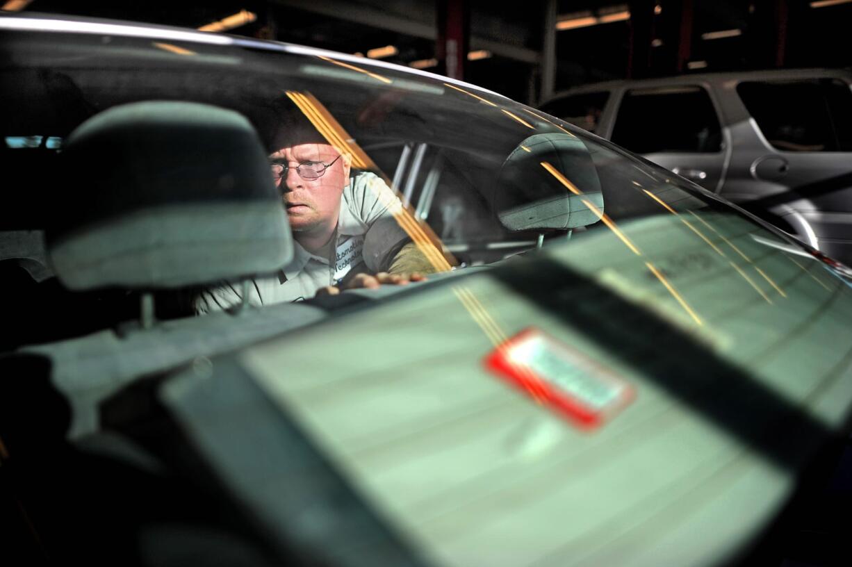 A student in Walla Walla Community College's Automotive Technology program, Scott Andrews works to install fabric seating in the rear seat of a Honda Civic that was flooded in Portland and brought to the school's shop for repair.