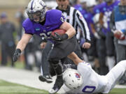 Linfield middle linebacker Skylor Elgarico (10) pulls St. Thomas running back Jordan Roberts (23) out of bounds during the first quarter during a Division III NCAA college football semifinal game on Saturday, Dec. 12, 2015, in St. Paul, Minn.