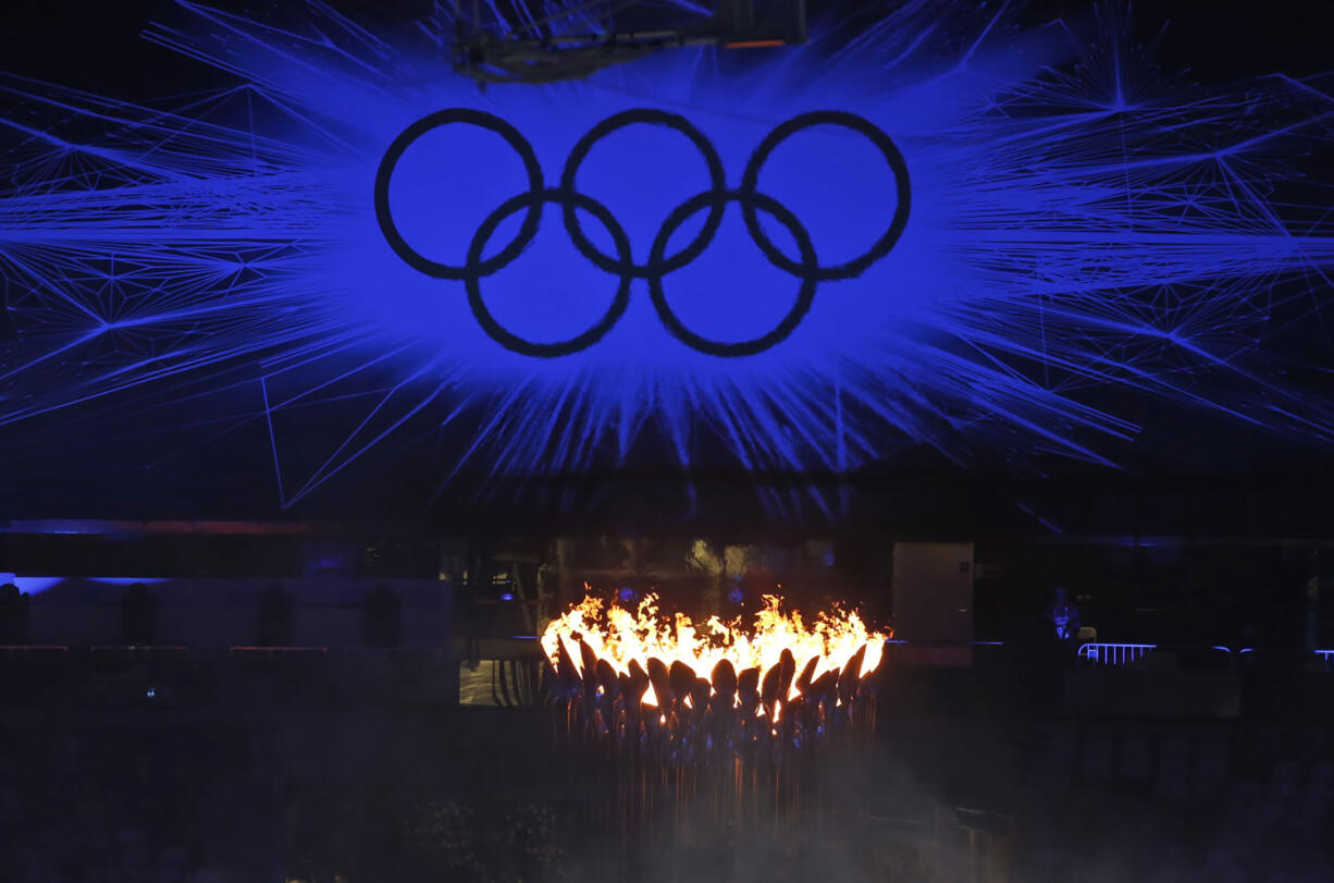 The Olympic Flame burns as the Olympic Rings stand illuminated during the Closing Ceremony at the 2012 Summer Olympics, Sunday, Aug. 12, 2012, in London.