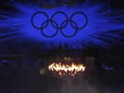 The Olympic Flame burns as the Olympic Rings stand illuminated during the Closing Ceremony at the 2012 Summer Olympics, Sunday, Aug. 12, 2012, in London.