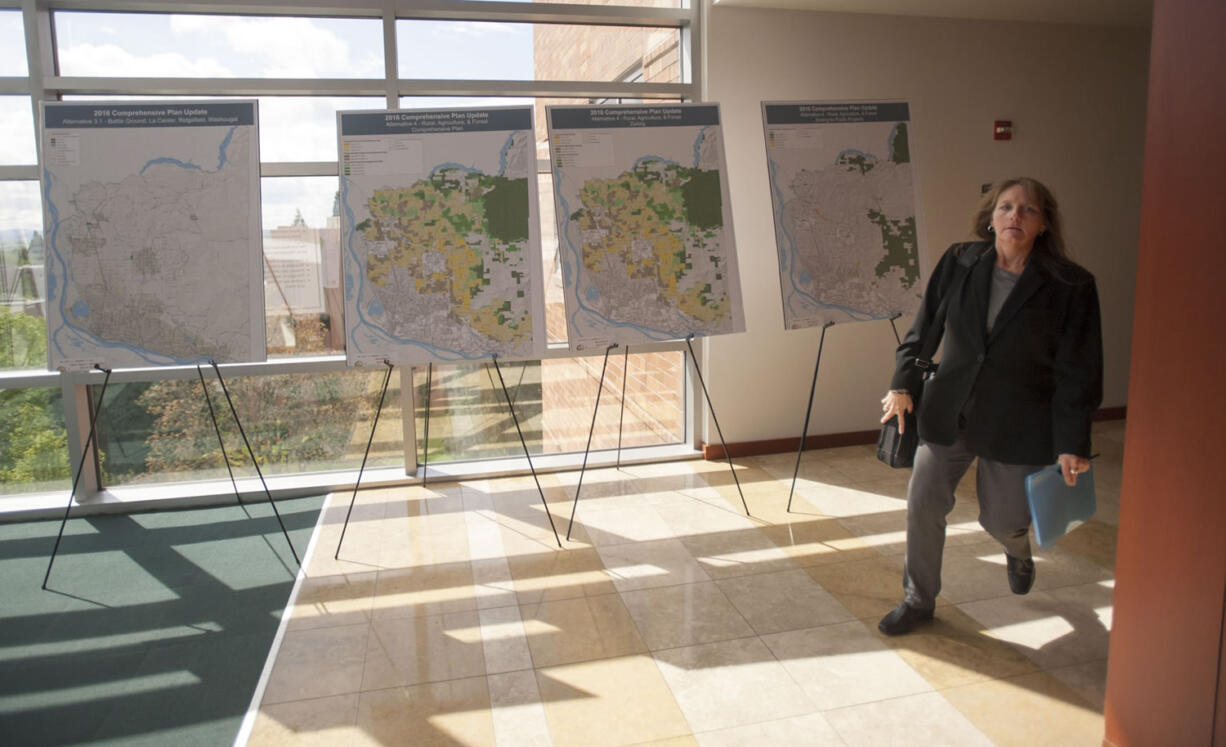 A woman walks past posters outlining land-use planning alternatives at the Clark County Public Service Center in Vancouver in April.