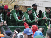 Portland Timbers players celebrate with fans during the MLS champions parade through Portland, Ore., Tuesday, Dec. 8, 2015.  The Timbers defeated the Columbus Crew 2-1 Sunday in the MLS Cup soccer final.