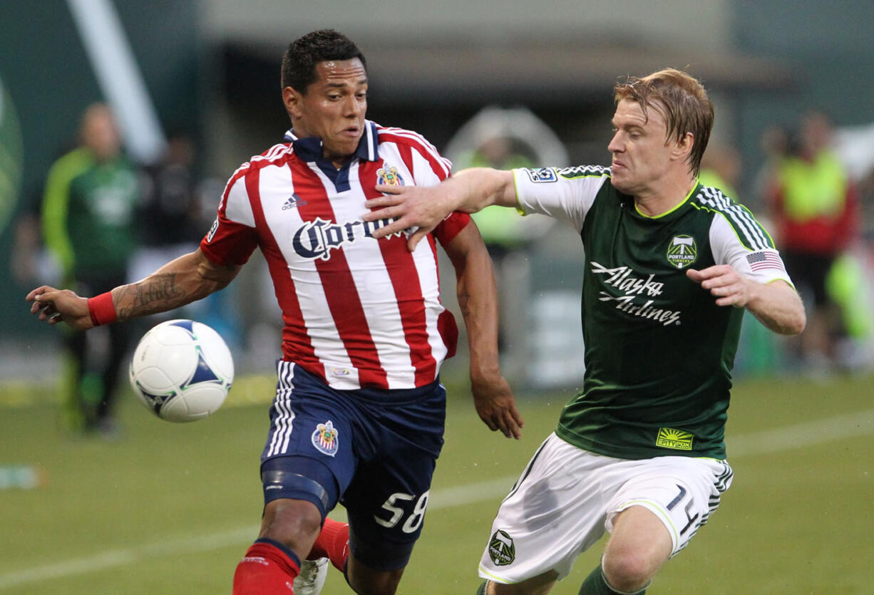 Portland Timbers' Steven Smith (14) defends against Chivas USA's Cesar Romero (58) in the first half Saturday at Jeld-Wen Field in Portland.