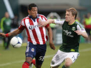 Portland Timbers' Steven Smith (14) defends against Chivas USA's Cesar Romero (58) in the first half Saturday at Jeld-Wen Field in Portland.