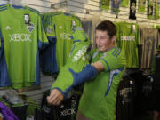 Evan Sacker, 14, of Vancouver puts on his newly-purchased Clint Dempsey No. 2 Seattle Sounders jersey Saturday in Seattle.