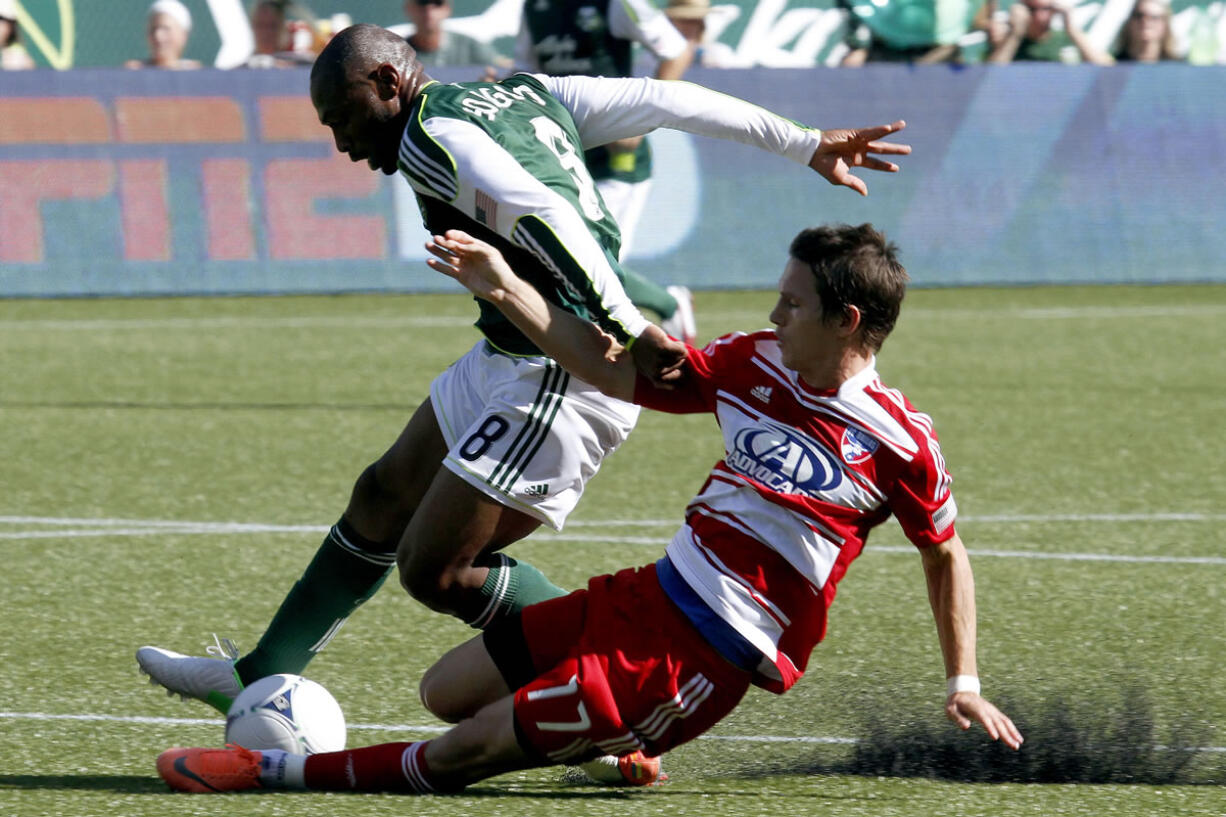 Portland Timbers forward Franck Songo'o, left, and FC Dallas defender Zach Loyd battle for the ball.