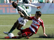 Portland Timbers forward Franck Songo'o, left, and FC Dallas defender Zach Loyd battle for the ball.