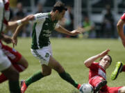 Portland Timbers midfielder Diego Valeri, left, is challenged by sliding FC Dallas defender Zach Loyd during the first half of the Timbers' 1-0 victory on June 9 at Jeld-Wen Field in Portland. The teams, who have split a pair of Major League Soccer matches this season, play today in Frisco, Texas, in the quarterfinals of the Lamar Hunt U.S.