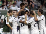 Teammates mob Los Angeles Galaxy midfielder David Beckham (not visible in middle of crowd) after he scores his second goal of the first half against the Timbers.