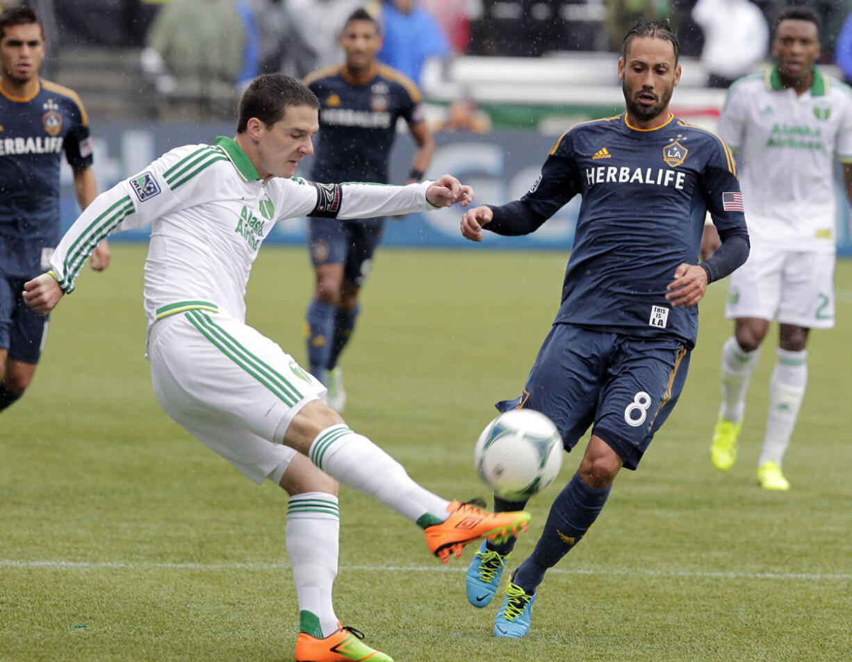 Portland Timbers midfielder Will Johnson, left, kicks the ball away from Los Angeles Galaxy midfielder Marcelo Sarvas during the first half Sunday.