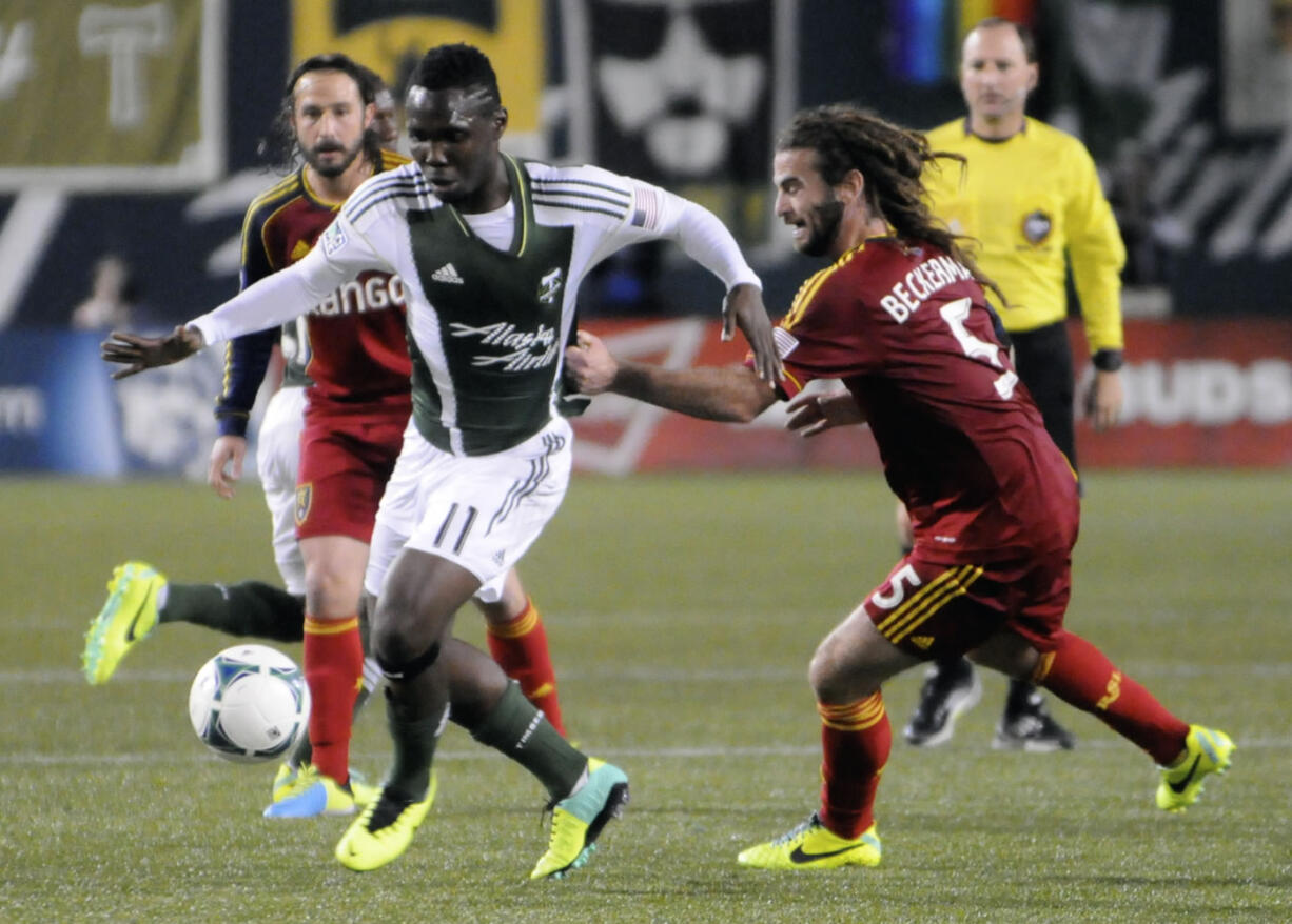 Portland Timbers' Kalif Alhassan (11)works against Real Salt Lake's Kyle Beckerman (5) during the first half of an MLS Soccer game in Portland, Ore., Saturday, Oct. 19, 2013.