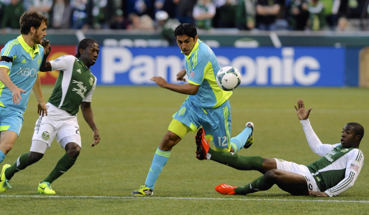 Portland Timbers' Jose Adolfo Valencia (20) defends against Seattle's Leo Gonzalez (12) during the first half of an MLS Soccer game in Portland, Ore., Sunday Oct. 13, 2013.