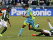 Portland Timbers' Jose Adolfo Valencia (20) defends against Seattle's Leo Gonzalez (12) during the first half of an MLS Soccer game in Portland, Ore., Sunday Oct. 13, 2013.