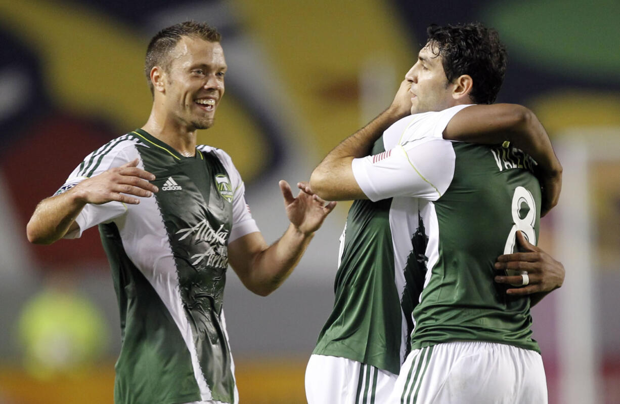 Portland Timbers defender Jack Jewsbury, left, comes in to celebrate with Timbers midfielder Darlington Nagbe, center, after Portland Timbers forward Diego Valeri's, right, second goal against Chivas USA during the first half of an MLS soccer match, Saturday, Oct. 26, 2013, in Carson, Calif.