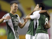 Portland Timbers defender Jack Jewsbury, left, comes in to celebrate with Timbers midfielder Darlington Nagbe, center, after Portland Timbers forward Diego Valeri's, right, second goal against Chivas USA during the first half of an MLS soccer match, Saturday, Oct. 26, 2013, in Carson, Calif.