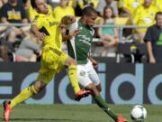 Portland Timbers' Ryan Johnson, right, tries to kick the ball past Columbus Crew's Chad Barson during the first half Sunday at Columbus, Ohio.