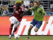 Portland Timbers' Bright Dike, left, drives toward the goal as Seattle Sounders' Adam Johansson, right, defends, in the first half Sunday.