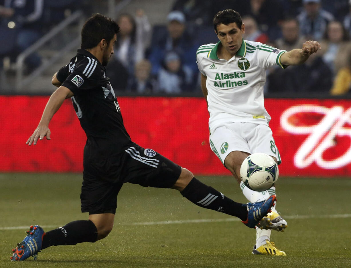 Portland Timbers midfielder Diego Valeri kicks past Sporting KC midfielder Paulo Nagamura during the first half  in Kansas City, Kan., Saturday.