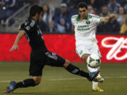 Portland Timbers midfielder Diego Valeri kicks past Sporting KC midfielder Paulo Nagamura during the first half  in Kansas City, Kan., Saturday.