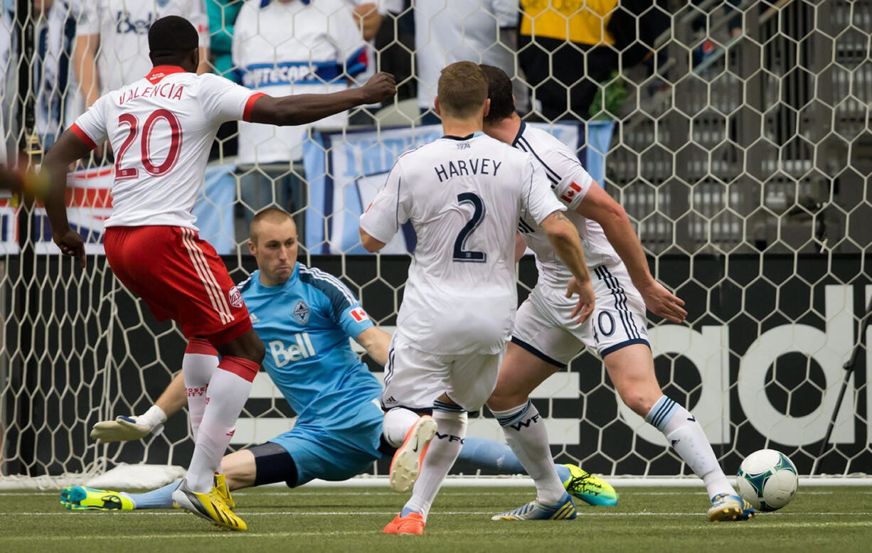 Portland Timbers' Jose Valencia (20) scores the tying goal against Vancouver Whitecaps' goalkeeper Brad Knighton as Jordan Harvey (2) and Andy O'Brien (40) defend during the second half Saturday.