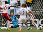 Portland Timbers' Jose Valencia (20) scores the tying goal against Vancouver Whitecaps' goalkeeper Brad Knighton as Jordan Harvey (2) and Andy O'Brien (40) defend during the second half Saturday.