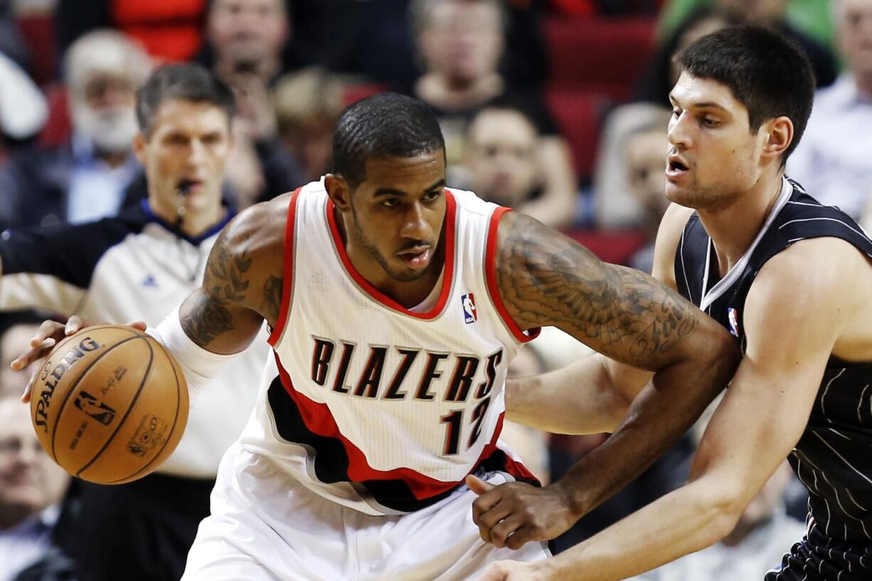 Portland Trail Blazers forward LaMarcus Aldridge (12) works against Orlando Magic center Nikola Vucevic during the first quarter Monday at the Rose Garden.