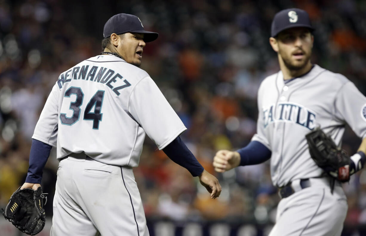 Mariners starting pitcher Felix Hernandez (34) reacts to a play by second baseman Dustin Ackley, right, for an out on Houston's Carlos Pena.