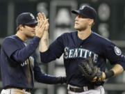 Seattle Mariners' Brad Miller, left, and Michael Saunders celebrate the Mariners' 4-2 win over the Houston Astros on Saturday in Houston.