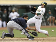 Seattle Mariners catcher Henry Blanco waits for the ball as Oakland Athletics' Jed Lowrie prepares to slide in the fifth inning Saturday.