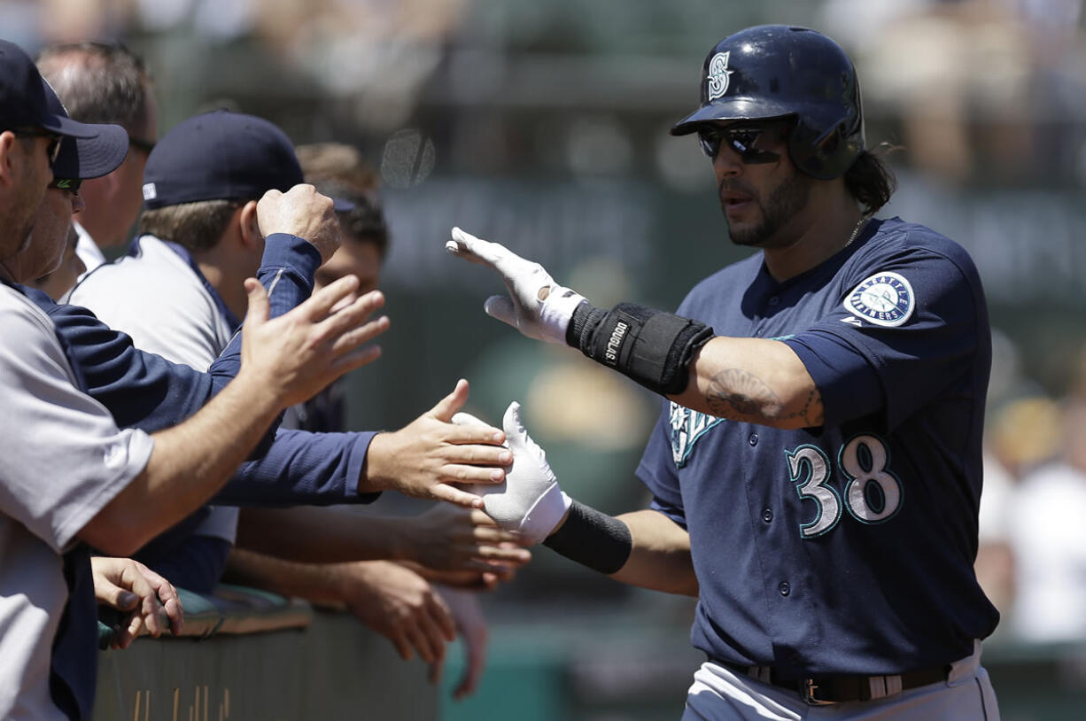 Seattle Mariners' Michael Morse (38) is congratulated after hitting a home run off Oakland Athletics' A.J. Griffin in the second inning of a baseball game on Wednesday, Aug. 21, 2013, in Oakland, Calif.