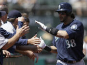 Seattle Mariners' Michael Morse (38) is congratulated after hitting a home run off Oakland Athletics' A.J. Griffin in the second inning of a baseball game on Wednesday, Aug. 21, 2013, in Oakland, Calif.