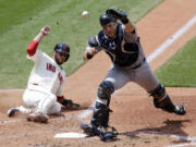 Cleveland Indians' Mike Aviles slides into home for a run to make the score 6-0 in the fourth inning Sunday as Seattle Mariners catcher Jesus Montero cannot hold on to the ball.