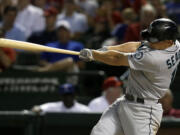 Seattle Mariners' Kyle Seager follows through on a two-run home run off a pitch from Texas Rangers' Robbie Ross in the 10th inning of a baseball game on Wednesday, July 3, 2013, in Arlington, Texas.