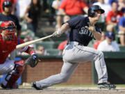 Seattle Mariners' Kyle Seager, right, follows through on a run-scoring double off a pitch from Texas Rangers closer Joe Nathan as catcher A.J. Pierzynski, left, watches in the ninth inning of a baseball game on Sunday, Aug. 18, 2013, in Arlington, Texas. The hit scored Mariners' Endy Chavez, giving the Mariners the lead and a 4-3 win.