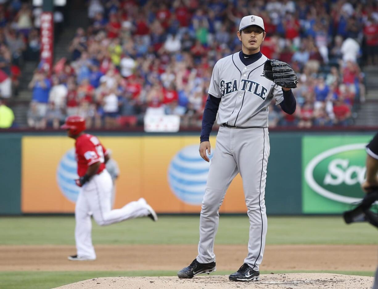 Seattle Mariners starting pitcher Hisashi Iwakuma waits for a new ball after giving up a solo home run to Texas Rangers' Adrian Beltre, background left, during the second inning Thursday.