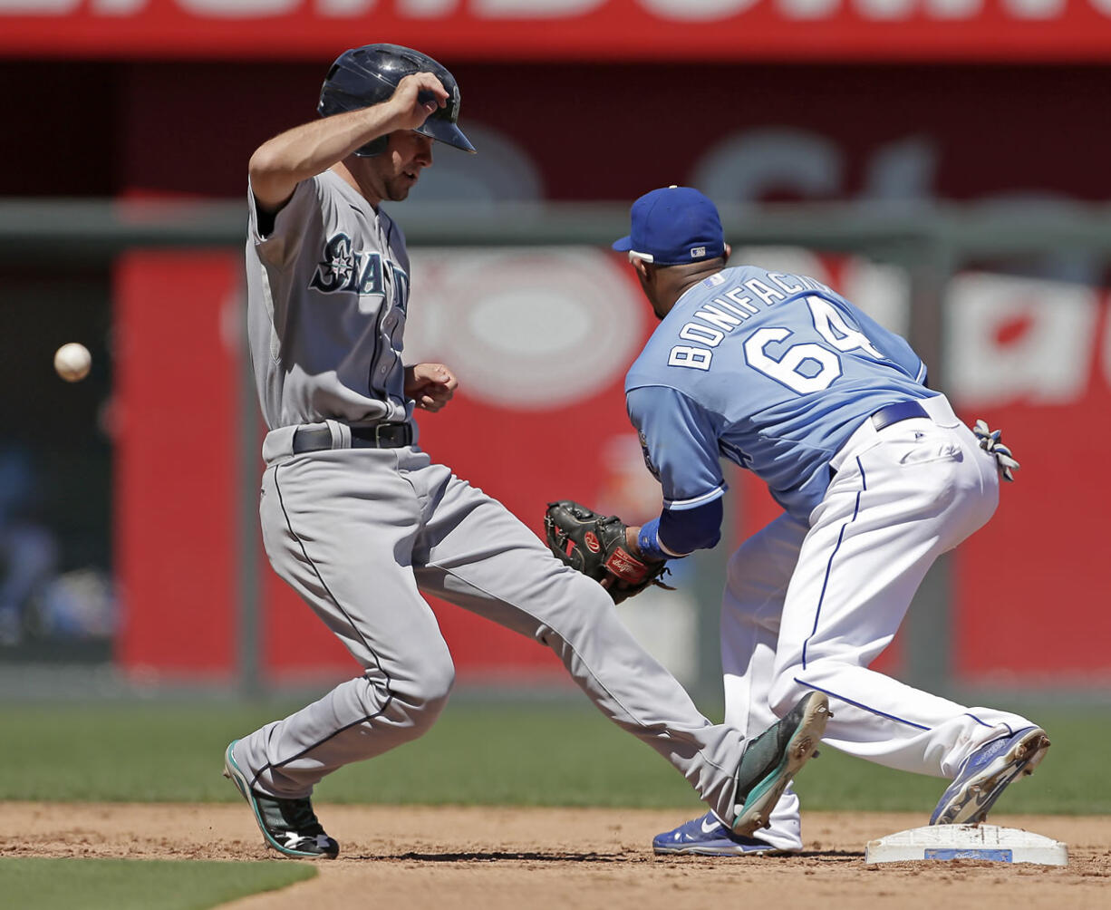 Seattle Mariners' Nick Franklin, left, beats the tag at second by Kansas City Royals second baseman Emilio Bonifacio as he runs back.