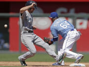 Seattle Mariners' Nick Franklin, left, beats the tag at second by Kansas City Royals second baseman Emilio Bonifacio as he runs back.