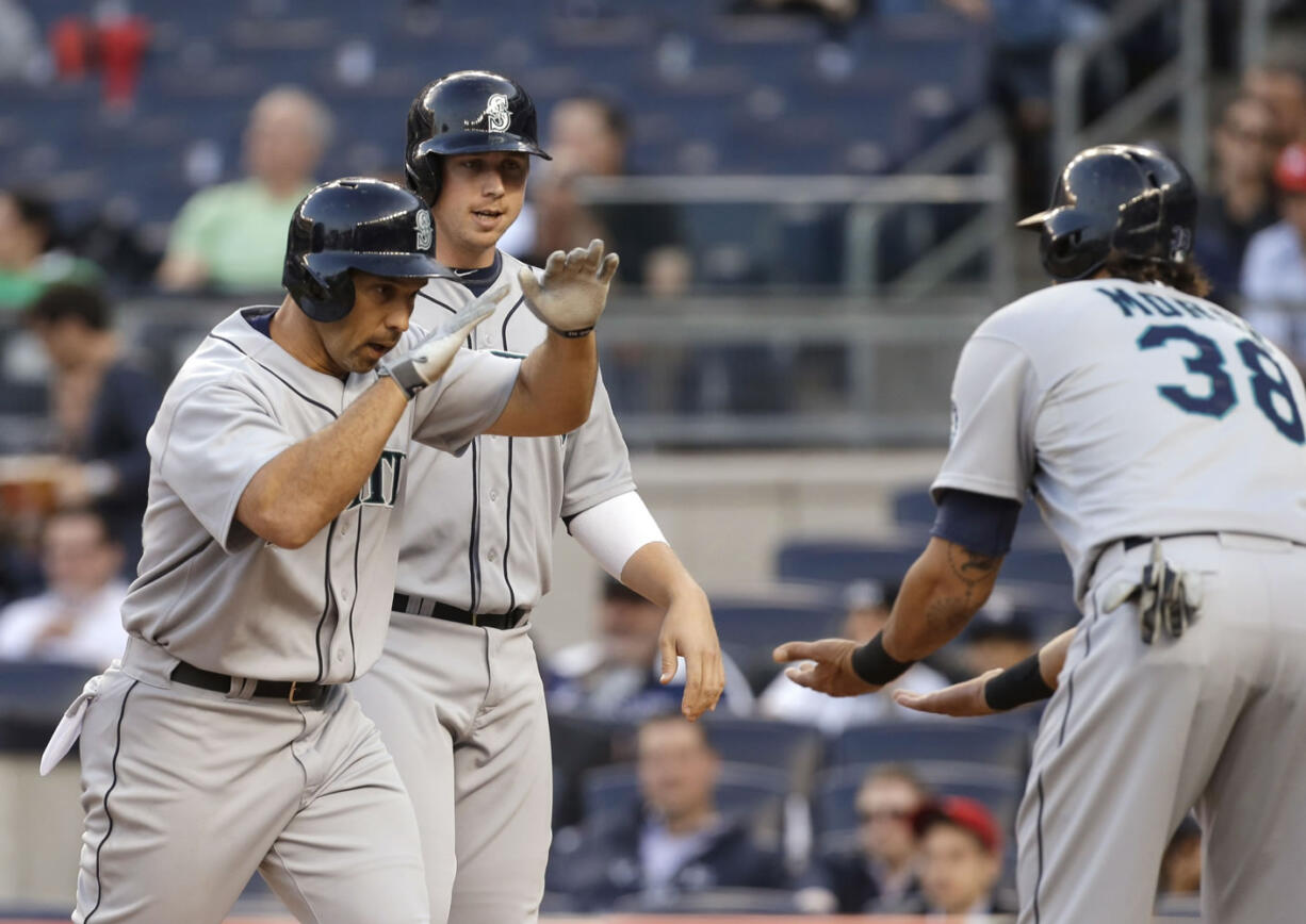 Seattle Mariners' Raul Ibanez, left, is congratulated by Michael Morse, right, after hitting a grand slam off New York Yankees starting pitcher Phil Hughes during the first inning of a baseball game at Yankee Stadium in New York, Wednesday, May 15, 2013.